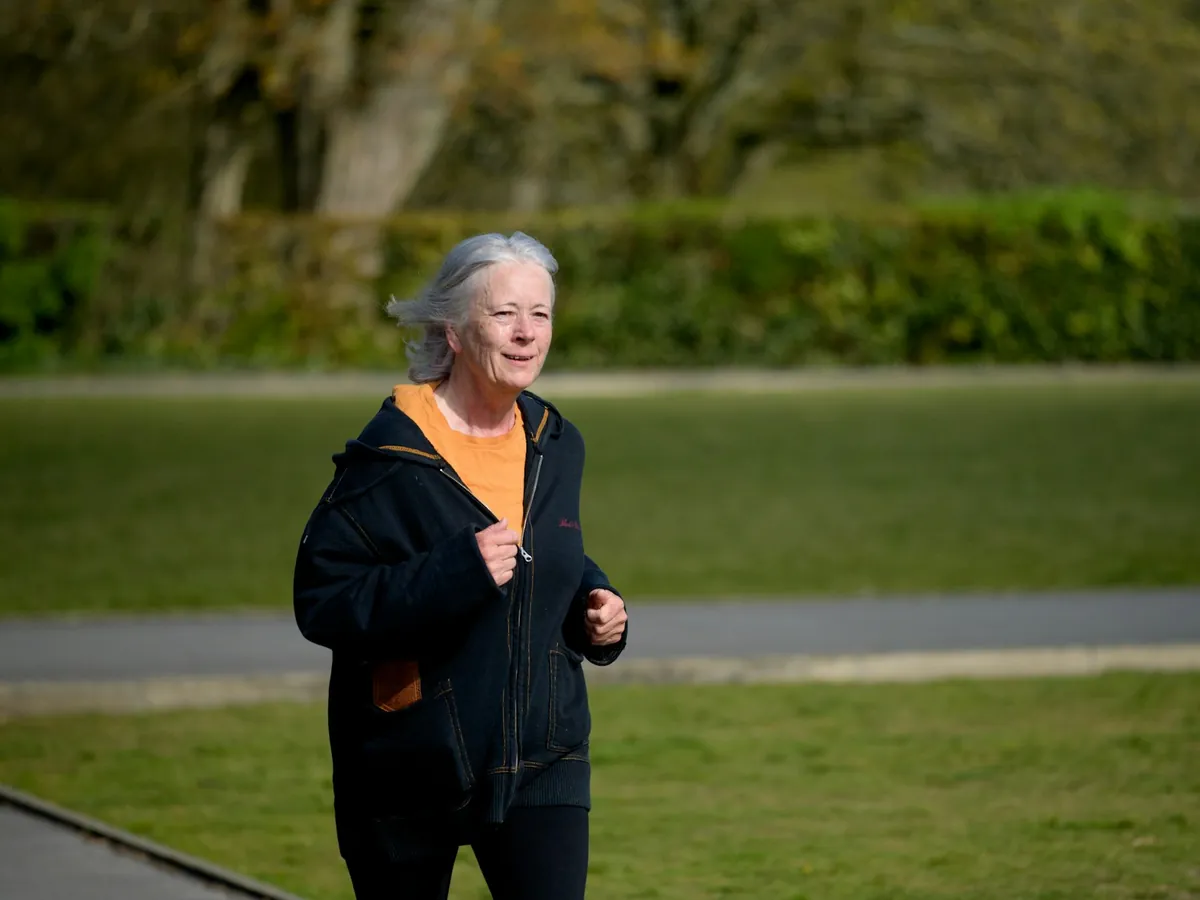 Mujer mayor trotando en un parque